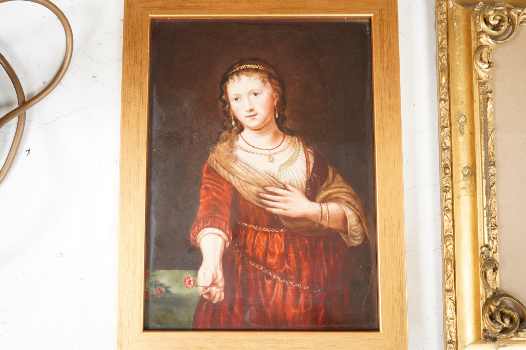 A Continental painted porcelain plaque of Saskia van Uylenburgh, after Rembrandt, together with another plaque of a young girl and her dog, after John Russell (2), Largest 17cm wide x 24cm high.